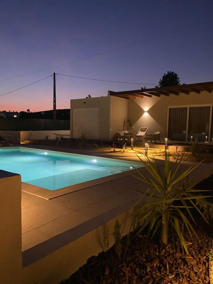 Projeto de iluminação noturna em piscina e zona de deck residencial